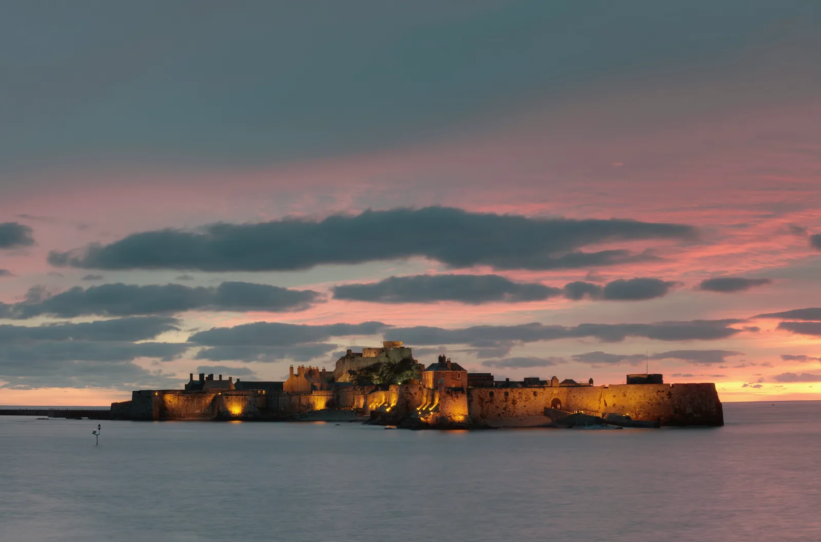 Elizabeth Castle lit at sunset off St Helier, Jersey