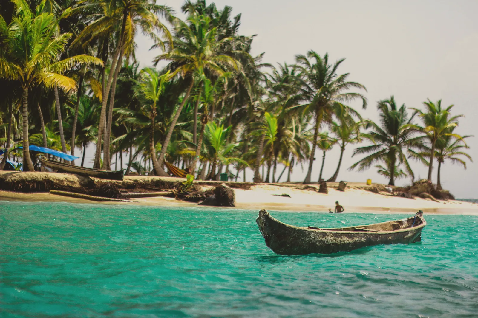 A canoe on a palm-fringed beach in Guna Yala, Panama