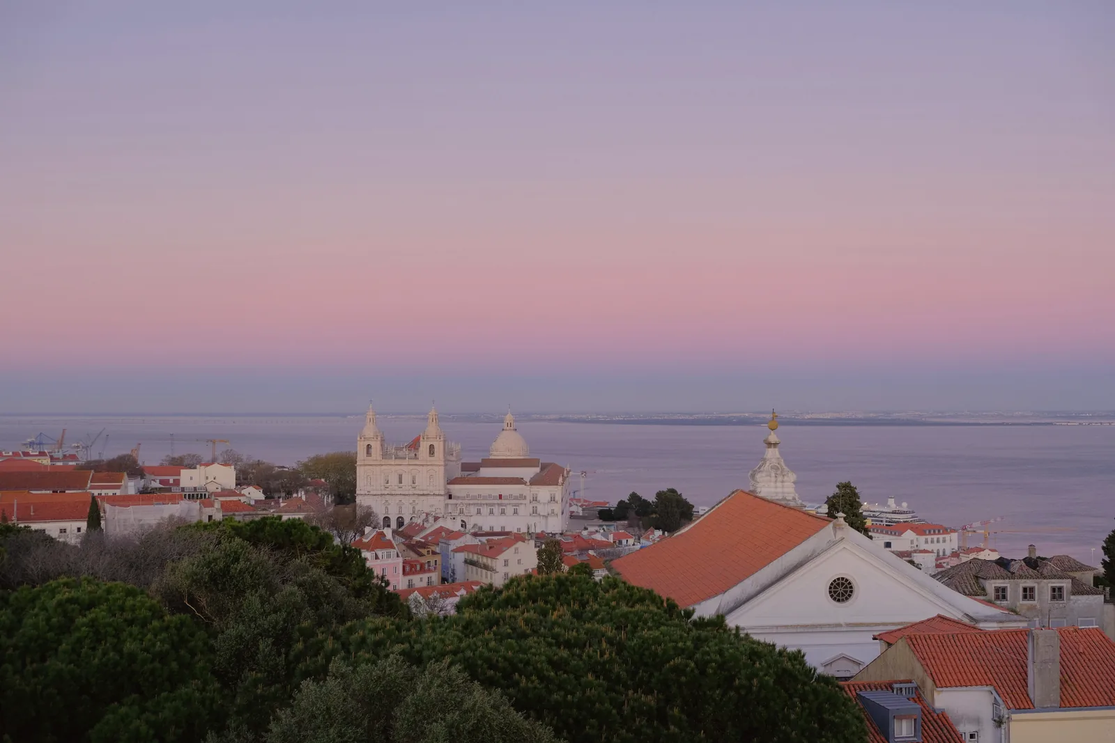 Lisbon rooftops at dusk above the Tagus