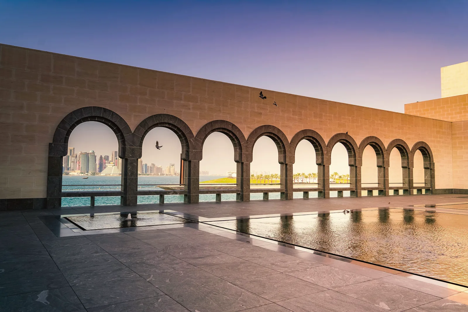 The arches of the Museum of Islamic Art framing the Doha skyline